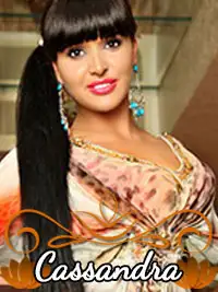 Smiling woman with long dark hair and colorful attire named Cassandra